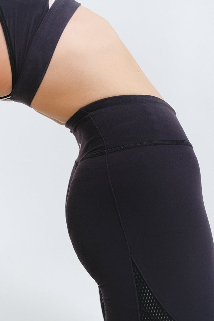 Detail of a woman in black activewear performing a stretch, showcasing fitness and healthy lifestyle.